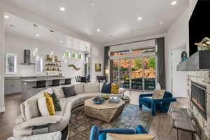 Living area featuring a fireplace, recessed lighting, healthy amount of natural light, and wood finished floors