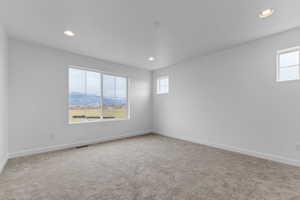 Spare room featuring a mountain view, light carpet, and recessed lighting