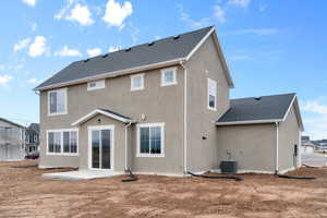 Back of property with a patio, stucco siding, and a shingled roof