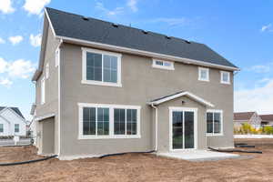Back of property with a patio area, stucco siding, and a shingled roof
