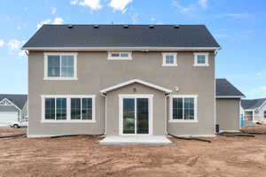 Back of house with stucco siding, a patio, and a shingled roof