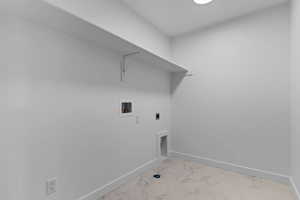 Laundry room with hookup for an electric dryer, light marble finish flooring, and washer hookup