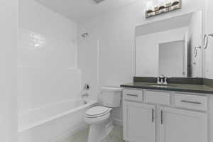 Bathroom featuring shower / washtub combination, vanity, and light marble finish floors