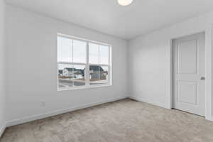 Spare room with light colored carpet and a residential view