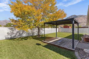 Fenced backyard with a deck with mountain view