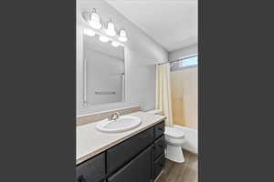 Bathroom featuring vanity, dark wood-type flooring, and shower / bath combination with curtain