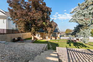 Rear view of property with a patio, a fenced backyard, brick siding, and a shingled roof
