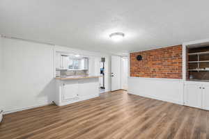 Unfurnished living room with a textured ceiling and light wood-type flooring