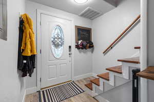 Entryway with light wood finished floors and stairway