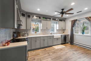 Kitchen with gray cabinetry, light wood finished floors, tasteful backsplash, recessed lighting, and light stone counters