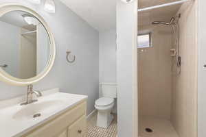 Full bathroom featuring vanity, a stall shower, and light tile patterned floors