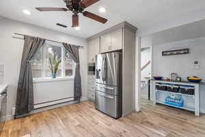 Kitchen with appliances with stainless steel finishes, gray cabinetry, light wood-style floors, a ceiling fan, and recessed lighting