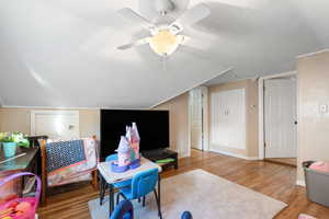 Rec room with a textured ceiling, wood finished floors, ceiling fan, and lofted ceiling