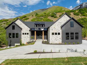 View of front of property featuring covered porch, stone siding, and a mountain view