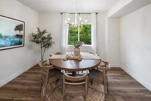 Dining area featuring dark wood-type flooring and a chandelier