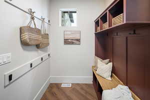 Mudroom with dark wood-style flooring and baseboards