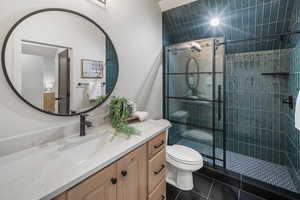 Full bathroom with vanity, a walk in shower, and dark tile patterned floors