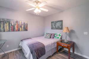 Bedroom featuring wood finished floors, ceiling fan, and a textured ceiling