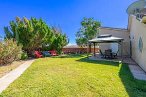 Fenced backyard featuring a patio and a gazebo