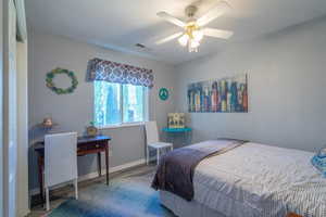 Bedroom with wood finished floors and a ceiling fan
