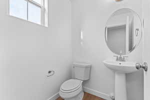 Bathroom featuring toilet and wood finished floors