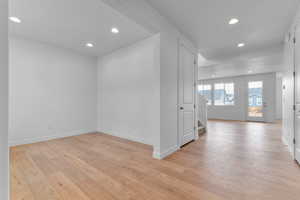 Spare room with recessed lighting, light wood-style floors, and stairs