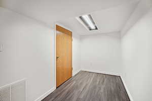 Empty room featuring dark wood finished floors and baseboards