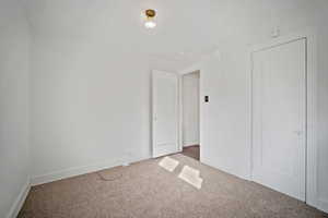 Unfurnished bedroom featuring baseboards and carpet flooring