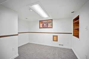 Carpeted empty room with recessed lighting