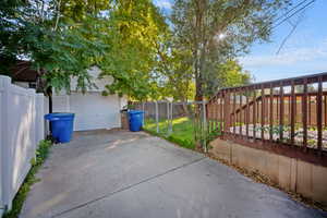 View of patio with an outbuilding, a garage, and driveway