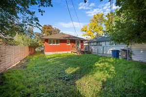 Rear view of property with a fenced backyard and brick siding