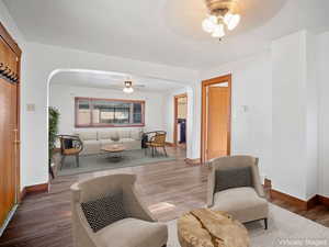 Sitting room featuring a ceiling fan, arched walkways, and wood finished floors