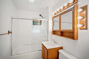 Full bathroom with shower / bath combination with glass door and vanity