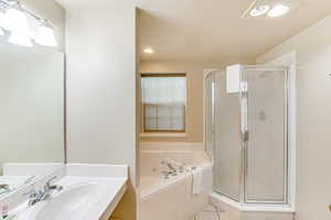 Bathroom with a shower stall, vanity, light tile patterned floors, a whirlpool tub, and a textured ceiling