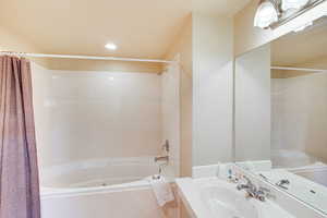 Bathroom featuring shower / tub combo, vanity, tile patterned floors, and recessed lighting
