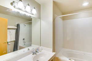 Full bathroom featuring shower / bathtub combination with curtain, vanity, and recessed lighting