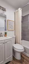 Bathroom featuring vanity, dark wood-style flooring, and shower / tub combo
