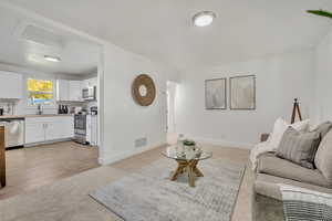 Living area with light carpet and baseboards