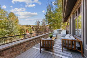 Deck with an outdoor hangout area and area for grilling