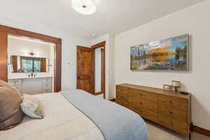 Bedroom with light colored carpet and baseboards