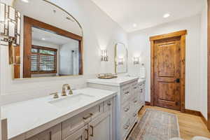 Bathroom featuring two vanities, recessed lighting, and light wood-style floors