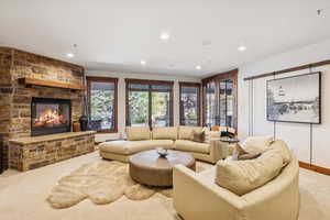 Living room with carpet flooring, a fireplace, and recessed lighting