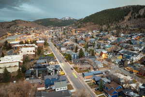 Aerial overview of property's location featuring a mountain backdrop and nearby suburban area