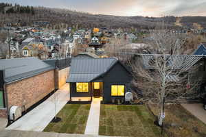 View of front facade featuring a lawn, a standing seam roof, a residential view, a metal roof, and heating fuel
