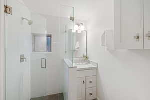 Bathroom featuring vanity and a stall shower