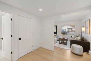 Hall with light wood-style flooring and recessed lighting