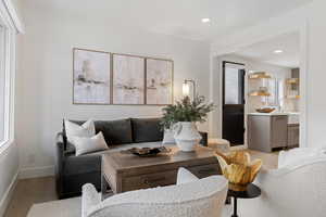 Living room with light wood-style flooring and recessed lighting
