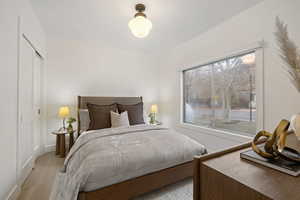 Bedroom with wood finished floors and a closet
