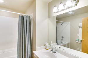 Bathroom featuring shower / bath combination with curtain and vanity