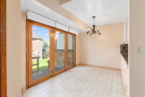 Unfurnished dining area featuring a chandelier and light wood finished floors